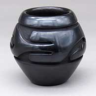 A small black jar with a stylized avanyu design carved around the shoulder
 by Sunday Chavarria of Santa Clara