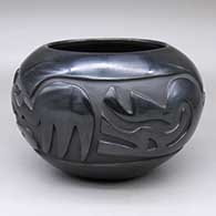 A black bowl carved with a stylized avanyu and geometric design
 by Mary Cain of Santa Clara