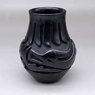 A black jar carved with an avanyu and ring-of-feathers design
 by Teresita Naranjo of Santa Clara