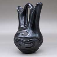 A black wedding vase carved around the body with an avanyu and geometric design, click or tap to see a larger version