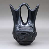 A black wedding vase carved around the body with an avanyu and geometric design, click or tap to see a larger version