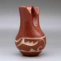 A red wedding vase carved with an avanyu design around the body, click or tap to see a larger version