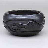 A black bowl carved around the body with an avanyu design
 by Warren Cain of Santa Clara