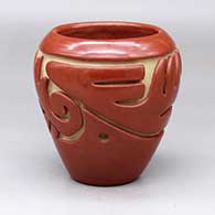 A red jar carved with an avanyu and geometric design around the body
 by Teresita Naranjo of Santa Clara