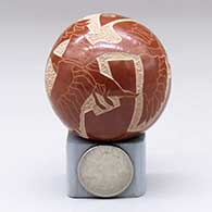 A miniature red seed pot decorated with a sgraffito flying geese and geometric design, click or tap to see a larger version