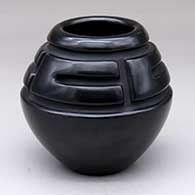 A black jar carved with a four-panel band of geometric design above the shoulder
 by Toni Roller of Santa Clara