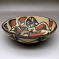 A large, open bowl decorated inside with a bird, plant, flower and geometric design and outside with a band of geometric design around the body, click or tap to see a larger version