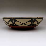A large, open bowl decorated inside with a bird, plant, flower and geometric design and outside with a band of geometric design around the body, click or tap to see a larger version