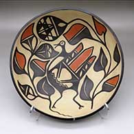 A large, open bowl decorated inside with a bird, plant, flower and geometric design and outside with a band of geometric design around the body
 by Paulita Pacheco of Santo Domingo