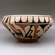 A large, open polychrome bowl decorated with a bird element and geometric design around the body, click or tap to see a larger version