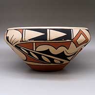 A large, open polychrome bowl decorated with a bird element and geometric design around the body, click or tap to see a larger version