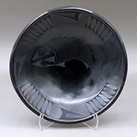 A black on black shallow bowl decorated with a fish and geometric design
 by Oscar Quezada of Mata Ortiz and Casas Grandes