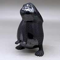 A black on black standing rabbit figure decorated with a checkerboard and geometric design
 by Macario Ortiz of Mata Ortiz and Casas Grandes