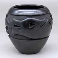 A black jar carved around the shoulder with an avanyu and geometric design
 by Mida Tafoya of Santa Clara