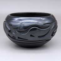 An open black bowl carved around the body with an avanyu and geometric design
 by Stella Chavarria of Santa Clara
