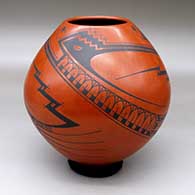 A black on red jar decorated with a three-panel bird element, serpent and geometric design
 by Juan Quezada Sr of Mata Ortiz and Casas Grandes