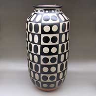 A tall polychrome cylinder decorated with a dot and geometric design
 by Thomas Tenorio of Santo Domingo
