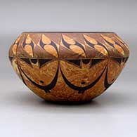 A black on mixed clay bowl decorated with bands of geometric design above and below the shoulder, click or tap to see a larger version