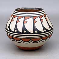 A polychrome bowl decorated with as feather design above the shoulder and a cloud geometric design below
 by Robert Tenorio of Santo Domingo