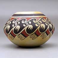 A polychrome jar decorated around the shoulder with a bat wing, bird element and geometric design, click or tap to see a larger version