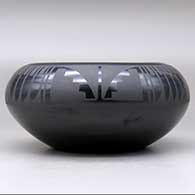 A black on black bowl decorated with a four-panel feather and geometric design above the shoulder, click or tap to see a larger version