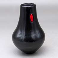 A black jar with a tall neck and a rosarita stone inlay
 by Michael Aguilar of San Ildefonso