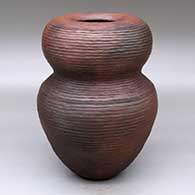 A brown double-lobed jar with exposed coils, an infinity rim and decorated with fire clouds
 by Jamie Zane Smith of Wyandot