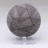 A black-on-white seed pot with a spiral, fine line and geometric design
 by Rebecca Lucario of Acoma