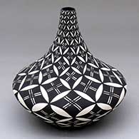 A black-on-white tall neck jar decorated with a North Star snowflake and geometric design
 by Sandra Victorino of Acoma