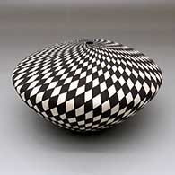 A black-on-white seed pot decorated with a spiraling checkerboard geometric design
 by Sandra Victorino of Acoma