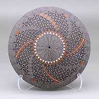 A polychrome seed pot decorated on the top with a North Star fine line medallion surrounded by a spiraling four-panel geometric design
 by Rebecca Lucario of Acoma