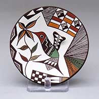 A small polychrome plate decorated with a hummingbird, flower, fine line and geometric design
 by Carolyn Concho of Acoma