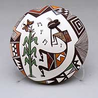 A polychrome seed pot decorated with a kokopelli, corn plant, fine line and geometric design
 by Carolyn Concho of Acoma