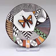 A polychrome plate with a butterfly applique and a fine line, feather and geometric design
 by George Concho of Acoma