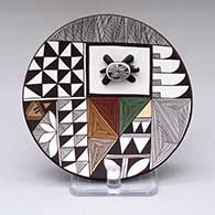 A polychrome plate with a turtle applique and a fine line and geometric design
 by George Concho of Acoma