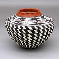A polychrome jar with a pie crust rim and decorated around the body with a black-on-white basket-weave geometric design
 by Cletus Victorino of Acoma