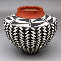 A polychrome jar with a pie crust rim and decorated around the body with a black-on-white basket-weave geometric design
 by Cletus Victorino of Acoma