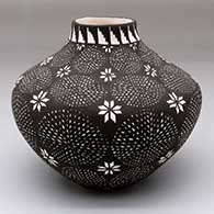 A black-on-white jar decorated with columns of fine line medallions and flower geometric designs
 by Sandra Victorino of Acoma