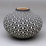 A black-on-white jar decorated with a spiraling geometric design
 by Paula Estevan of Acoma