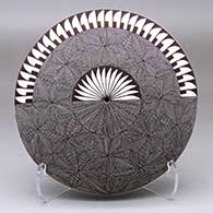 A black-on-white seed pot decorated with a feather, North Star, snowflake fine line and geometric design
 by Rebecca Lucario of Acoma