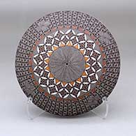 A polychrome seed pot decorated with a North Star fine line, pumpkin seed snowflake and geometric design
 by Rebecca Lucario of Acoma