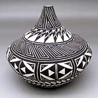 A black-on-white tear drop jar decorated with a scroll and geometric design
 by Sandra Victorino of Acoma