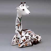 A polychrome giraffe figure decorated with a geometric design, plus a butterfly, bird and lady bugs
 by Judy Lewis of Acoma