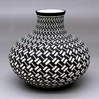 A black-on-white jar decorated with a basket-weave geometric design
 by Paula Estevan of Acoma