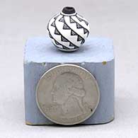 A miniature black-on-white jar decorated with a spiral mesa geometric design
 by LaDonna Victoriano of Acoma