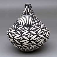 A black-on-white tear drop jar with a squarish opening and decorated with a pumpkin seed snowflake and four-panel feather and geometric design
 by Sandra Victorino of Acoma