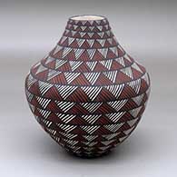 A polychrome jar decorated with bands of fine line geometric design
 by Sandra Victorino of Acoma