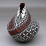 A polychrome jar with a kiva step cut opening and decorated with a pumpkin seed snowflake and geometric design
 by Sandra Victorino of Acoma