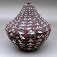 A polychrome jar decorated with bands of fine line rock art geometric design
 by Sandra Victorino of Acoma