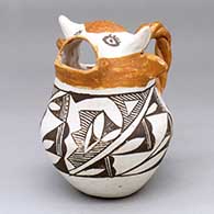 A polychrome cream pitcher with a cow head spout, twisted handle and black-on-white geometric design
 by Unknown of Acoma